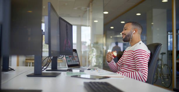 Businessman with headphones using computer for video call while sitting in office.